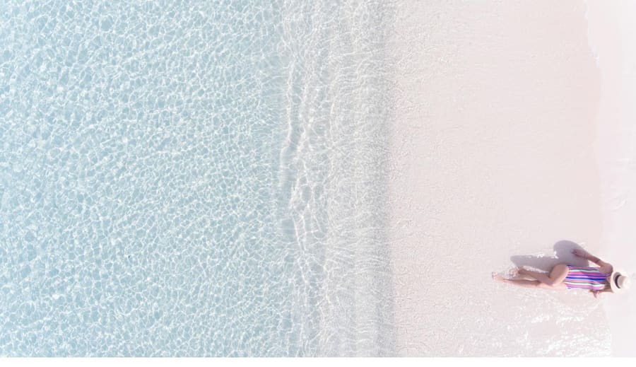 Shallow turquoise water along an empty white sand beach